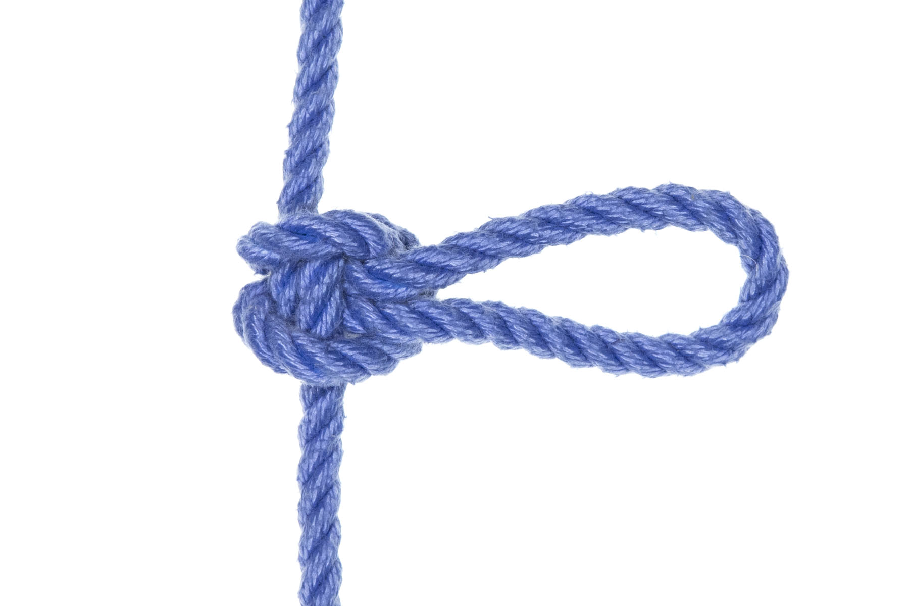 A completed alpine butterfly knot. A vertical line crosses the middle of the frame. There is a compact knot in the middle of the frame and a three inch bight extends out to the right.