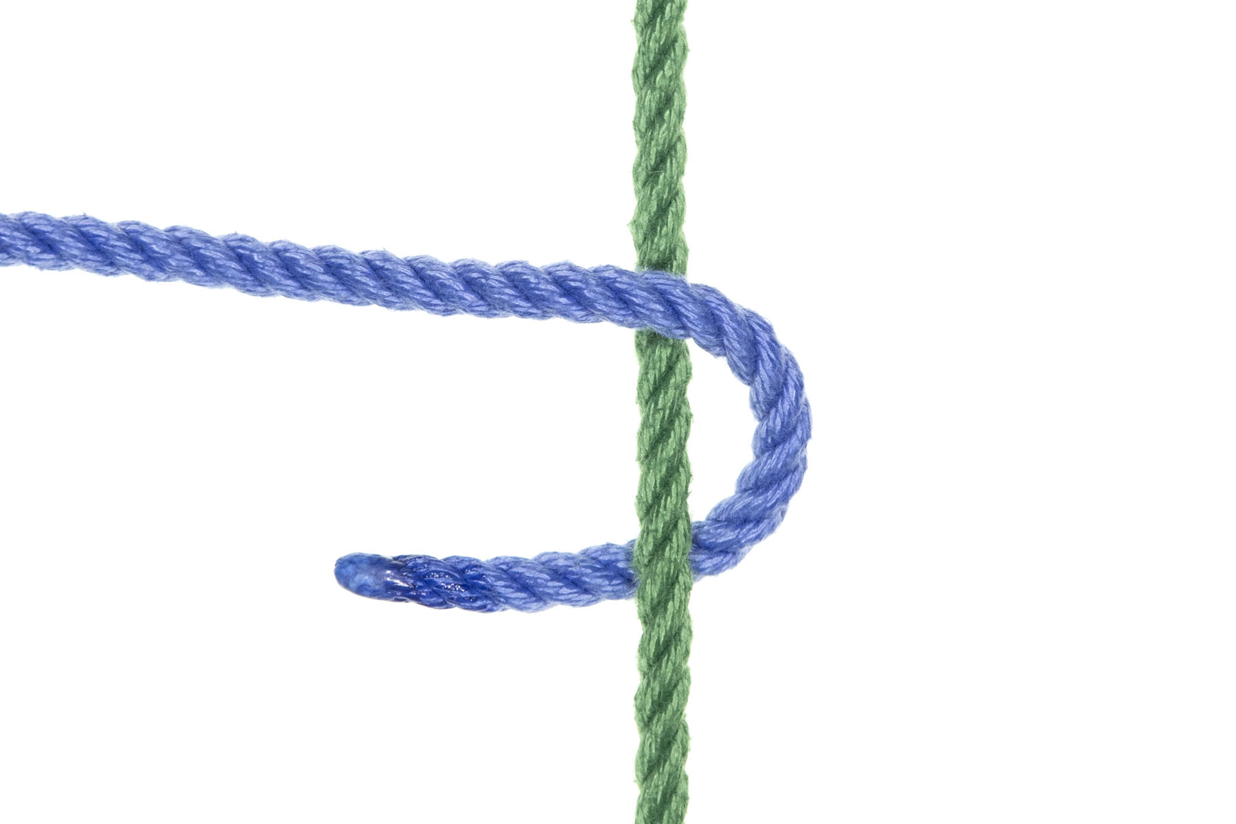 A single strand of green rope crosses the image vertically. A single strand of blue rope enters from the left and goes over and around the green rope, returning to the left slightly lower in the image than the standing part.