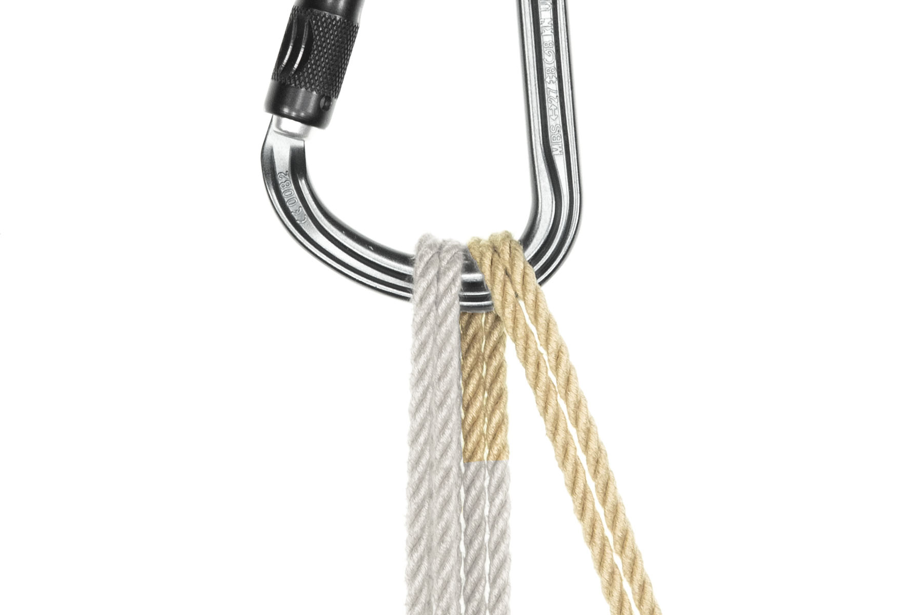 A pear-shaped carabiner hangs at the top of the image. Two passes of doubled tan rope go through the carabiner. The first, on the left side, comes up from behind the carabiner, passes through it from front to back, and exits at the bottom of the image. The second pass lies just to the right of the first pass. It comes up from behind the carabiner, passes through it from back to front, and travels down and to the right to exit the bottom of the frame.