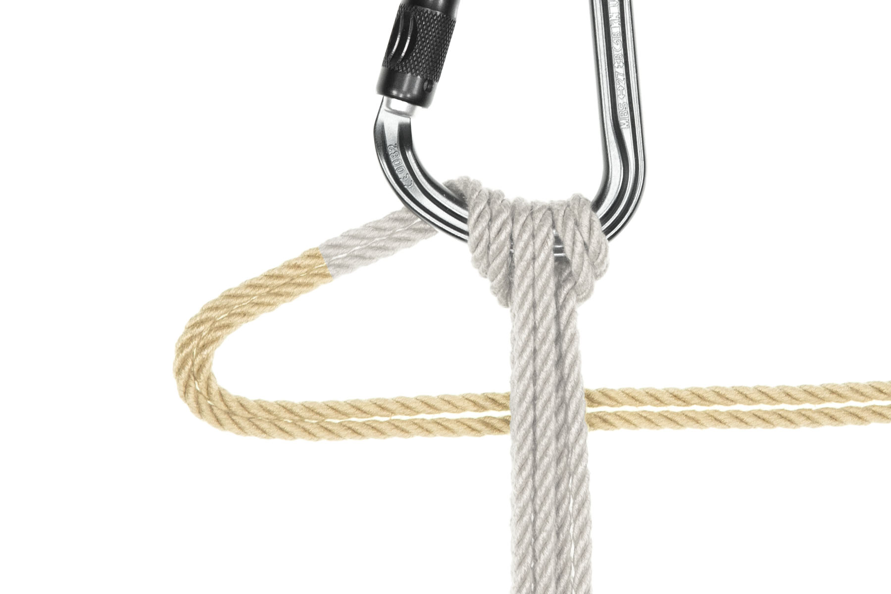 The tail of the rope now travels slightly to the left after exiting the back of the carabiner, then doubles back to the right, going behind all the vertical passes of the rope. It makes a 4 inch long triangle pointing to the left of the vertical passes.